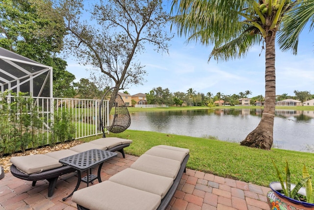 view of patio featuring a water view and a lanai