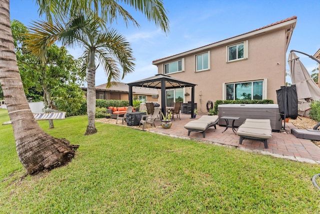 rear view of house featuring outdoor lounge area, a yard, a hot tub, a gazebo, and a patio area