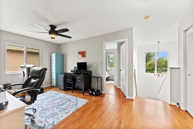 office area featuring ceiling fan, light wood-type flooring, and a textured ceiling