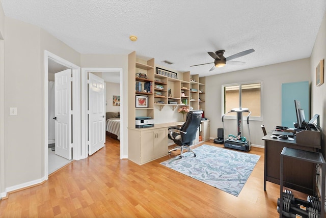 office space with ceiling fan, a textured ceiling, and light wood-type flooring