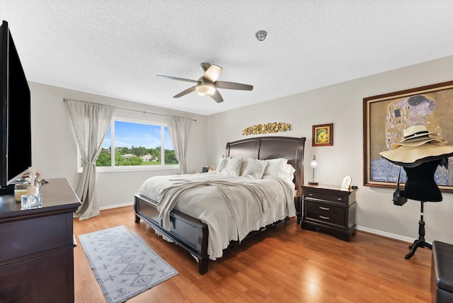 bedroom featuring hardwood / wood-style floors, a textured ceiling, and ceiling fan