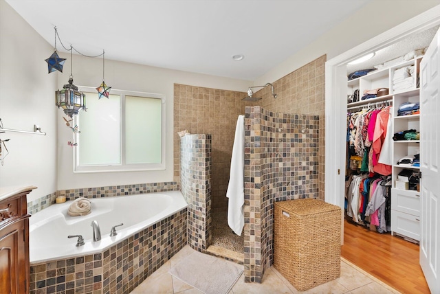 bathroom featuring tile patterned flooring, vanity, and independent shower and bath