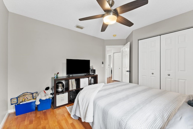 bedroom featuring ceiling fan, a closet, and hardwood / wood-style flooring