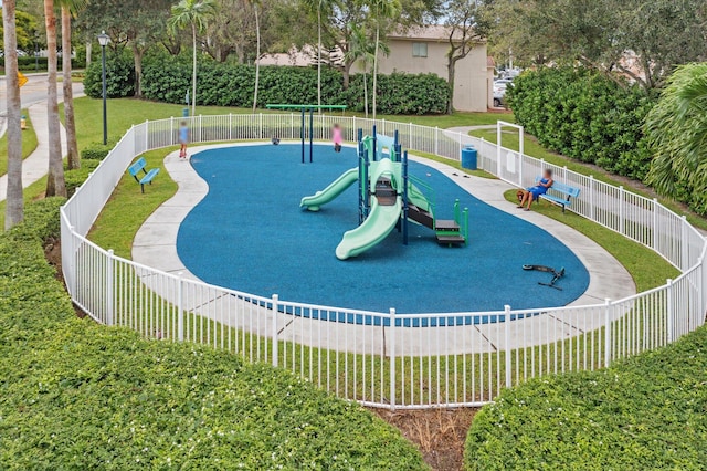 view of property's community featuring a playground and a lawn