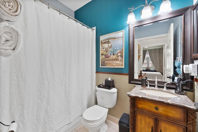 bathroom featuring toilet, vanity, tile patterned floors, and tile walls