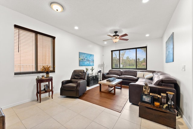 tiled living room with ceiling fan and a textured ceiling