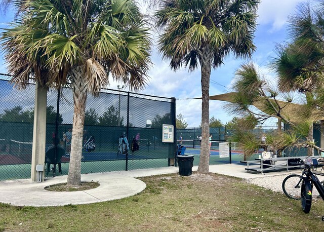 exterior space featuring a tennis court and fence