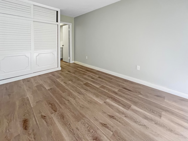 unfurnished bedroom featuring wood-type flooring and a closet