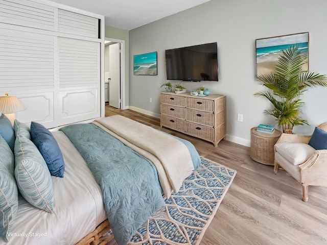 bedroom with baseboards and wood finished floors