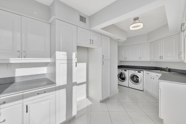 laundry room featuring light tile patterned floors, separate washer and dryer, and sink