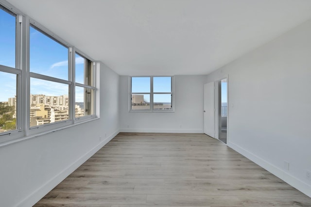 spare room featuring a wealth of natural light and light wood-type flooring