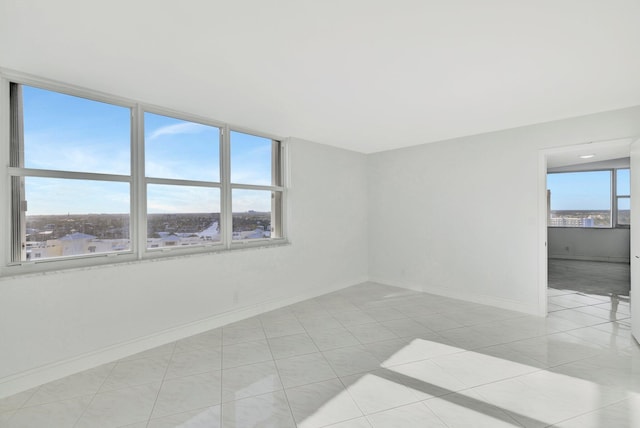 empty room featuring plenty of natural light and light tile patterned flooring