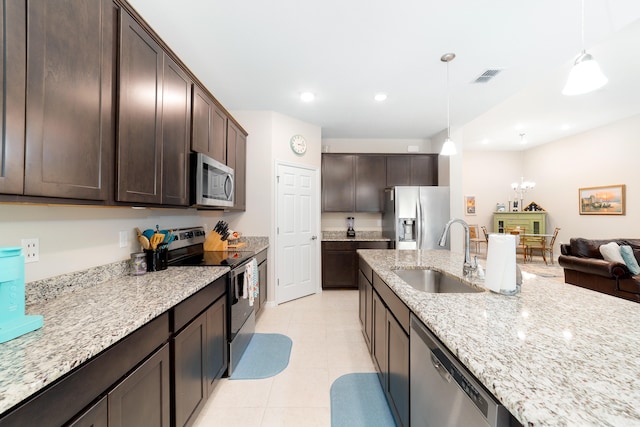 kitchen with stainless steel appliances, decorative light fixtures, dark brown cabinets, light stone countertops, and sink