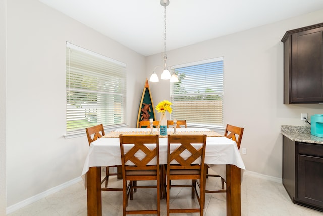 tiled dining area featuring a chandelier