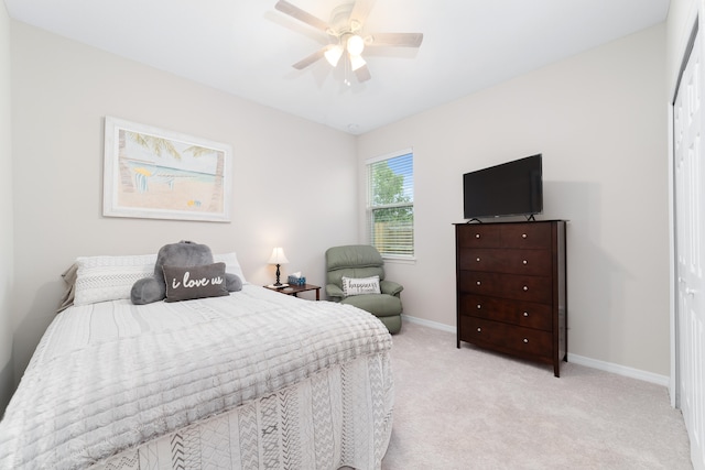 bedroom featuring ceiling fan, light carpet, and a closet