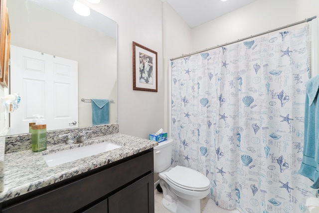 bathroom featuring curtained shower, vanity, and toilet