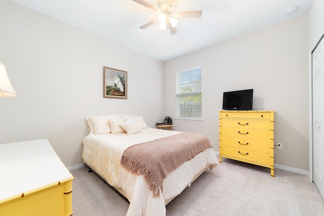 carpeted bedroom with ceiling fan and a closet