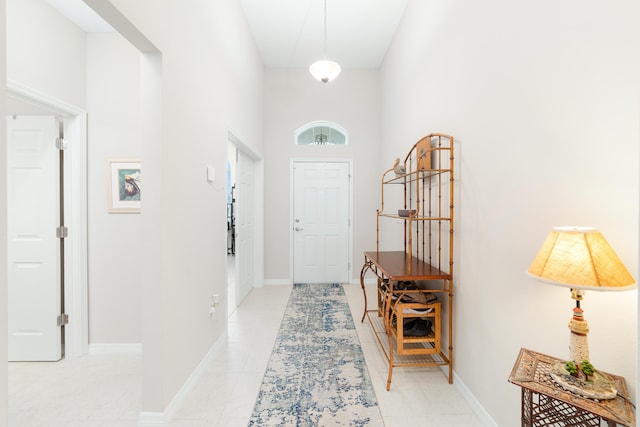 tiled foyer entrance with a towering ceiling