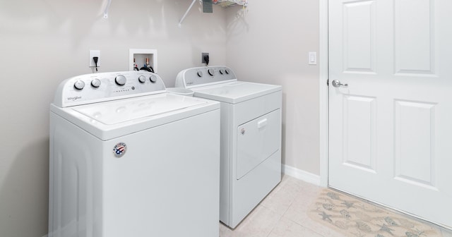 washroom with separate washer and dryer and light tile patterned floors