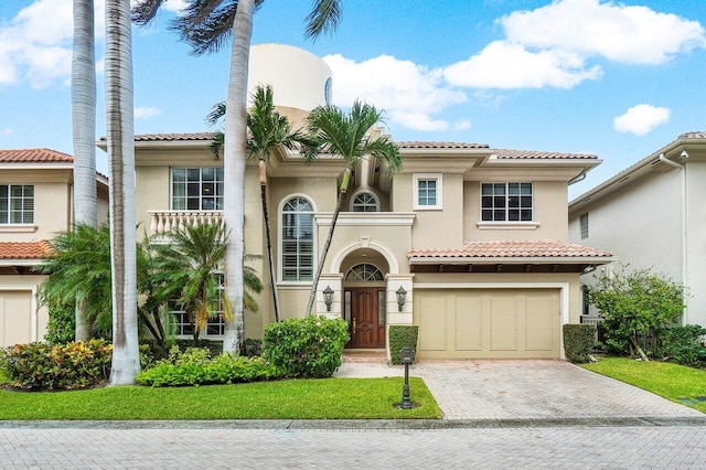 mediterranean / spanish-style home featuring a front lawn and a garage