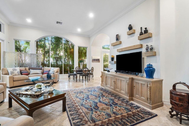 living room with a high ceiling and ornamental molding