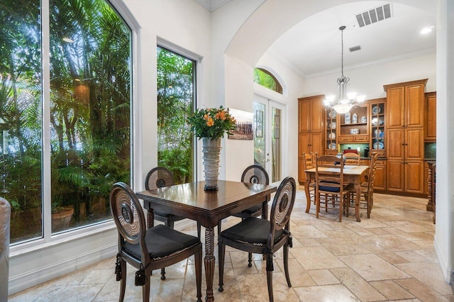 dining area with an inviting chandelier and ornamental molding