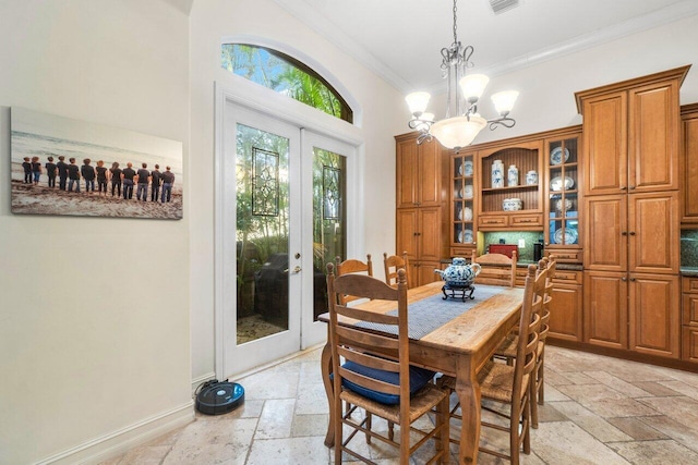 dining area featuring ornamental molding, french doors, and a notable chandelier