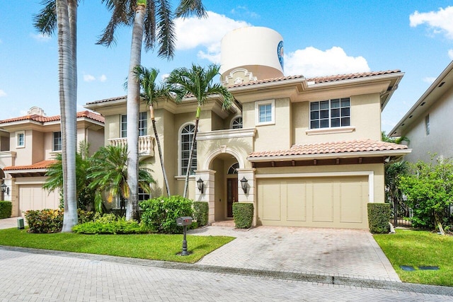 mediterranean / spanish house with a front lawn and a garage