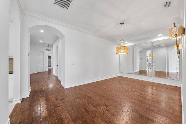 empty room featuring crown molding and wood-type flooring