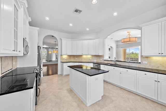 kitchen with a center island, white cabinets, and light tile patterned flooring