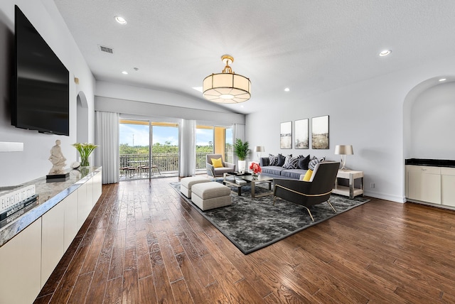 living room with a textured ceiling and dark hardwood / wood-style flooring