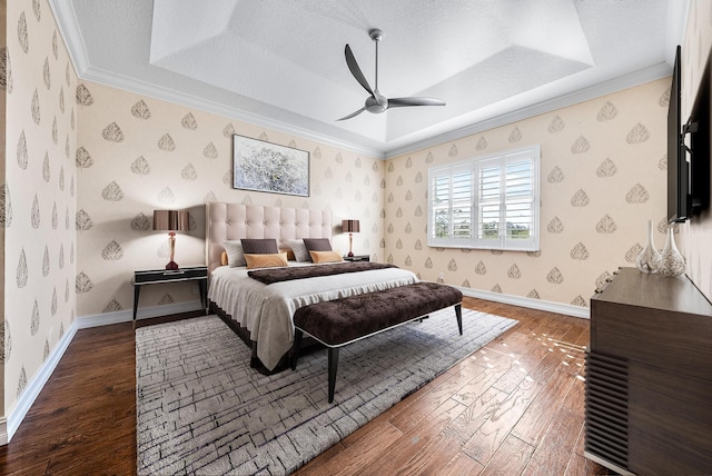 bedroom featuring hardwood / wood-style floors, a textured ceiling, a raised ceiling, and ceiling fan