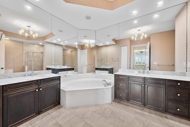 bathroom featuring vanity, a notable chandelier, and shower with separate bathtub