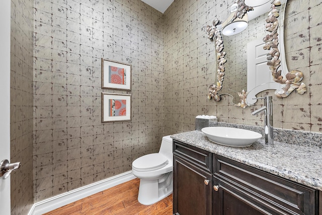 bathroom with hardwood / wood-style floors, vanity, and toilet