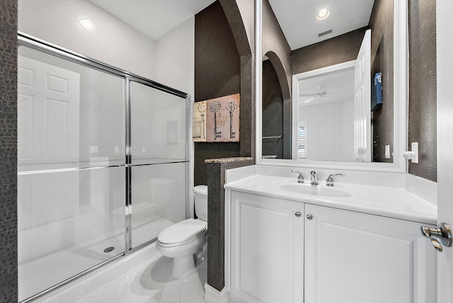 bathroom with an enclosed shower, vanity, toilet, and tile patterned flooring