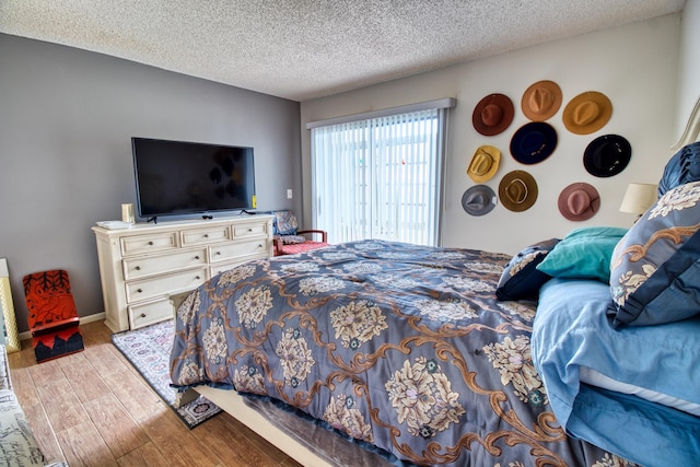 bedroom with light wood-type flooring and a textured ceiling