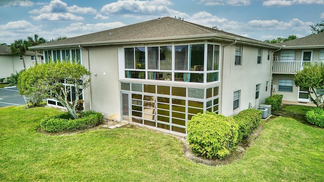 exterior space with cooling unit, a yard, and a balcony