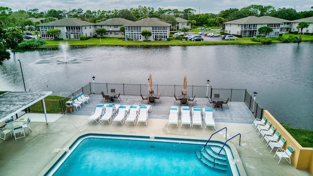 view of pool with a water view and a patio area