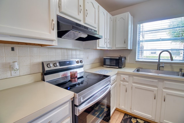 kitchen with stainless steel appliances, white cabinets, sink, and tasteful backsplash