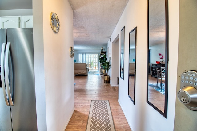 hallway featuring a textured ceiling and light wood-type flooring