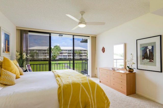 carpeted bedroom featuring access to exterior, a wall of windows, a textured ceiling, and ceiling fan