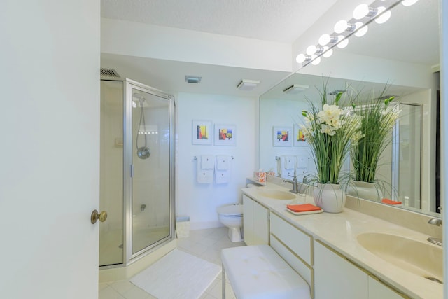 bathroom featuring vanity, toilet, a shower with shower door, and a textured ceiling