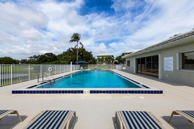 view of pool with a patio area and a water view