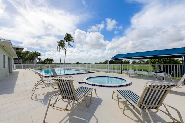 view of swimming pool with a patio area and a hot tub