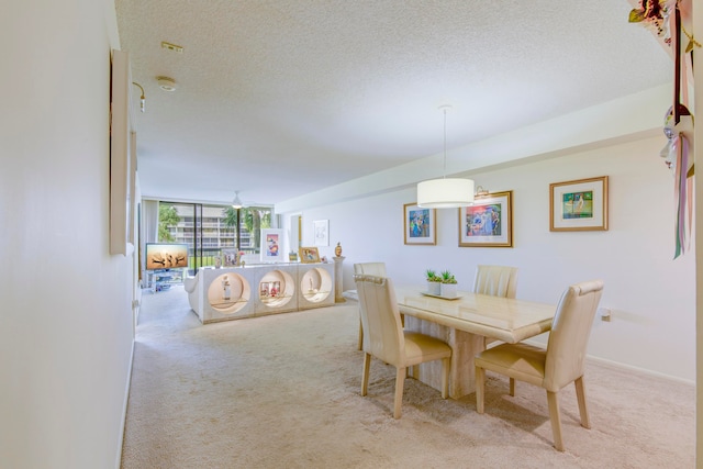 carpeted dining room featuring ceiling fan and a textured ceiling