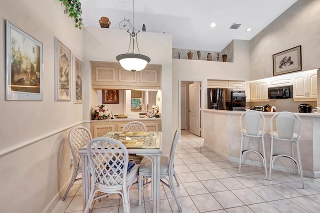 tiled dining space featuring a high ceiling