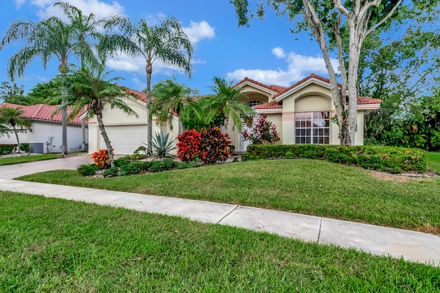 mediterranean / spanish-style house featuring a garage and a front yard