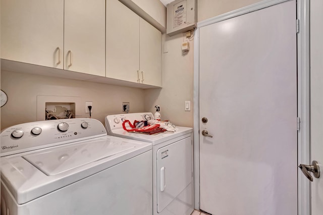 laundry room featuring separate washer and dryer and cabinets