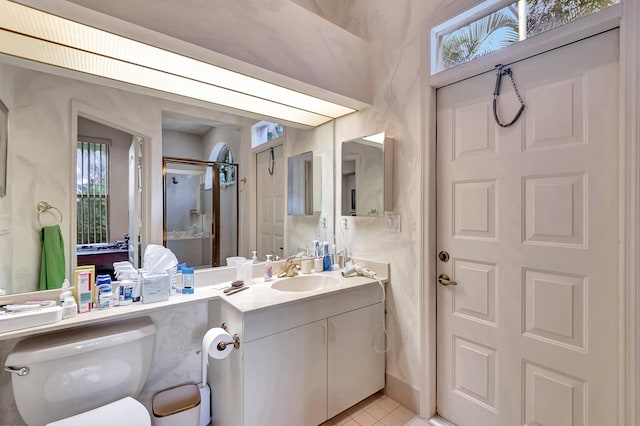 bathroom featuring plenty of natural light, toilet, a shower with shower door, and vanity