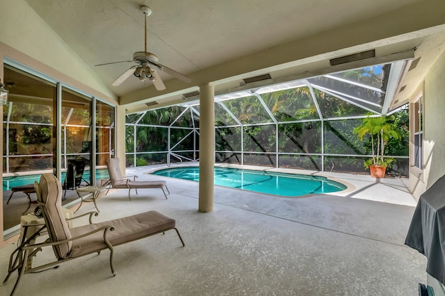 view of pool featuring a patio area, ceiling fan, and glass enclosure